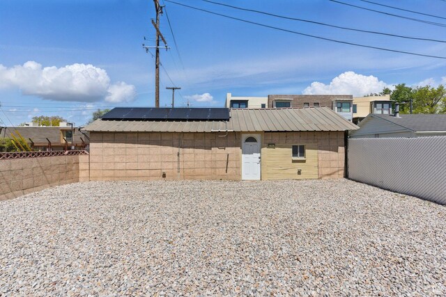 775 E Simpson Ave, Salt Lake City, UT 84106 - exterior space featuring a fenced backyard, roof mounted solar panels, and metal roof