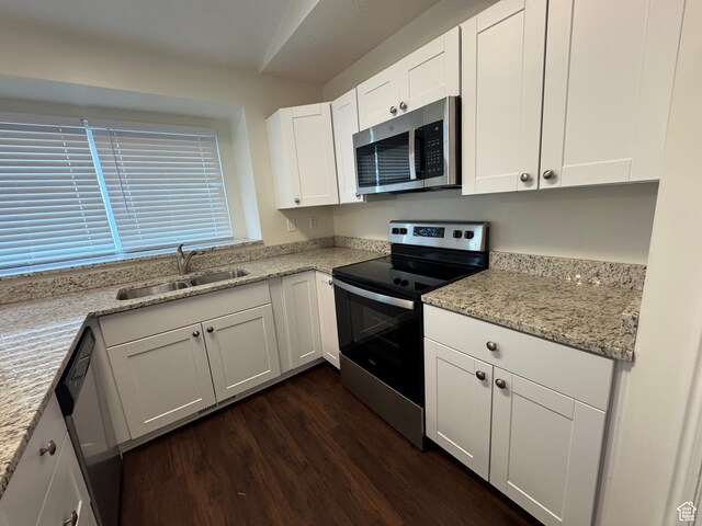 1952 E Sunset Dr, Layton, UT 84040 - kitchen with appliances with stainless steel finishes, light stone countertops, dark wood finished floors, a sink, and white cabinetry