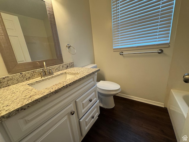 1952 E Sunset Dr, Layton, UT 84040 - bathroom featuring wood finished floors, vanity, baseboards, toilet, and a tub to relax in