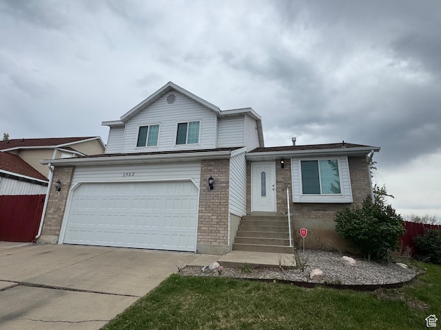 1952 E Sunset Dr, Layton, UT 84040 - split level home featuring brick siding, an attached garage, fence, and concrete driveway