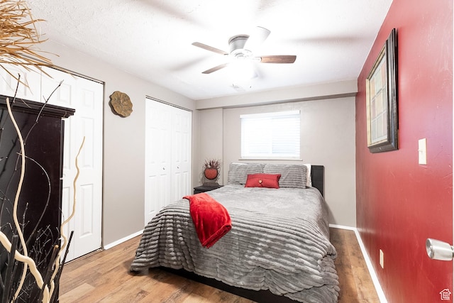 11622 S Worthington Ct E, Sandy, UT 84092 - bedroom with wood finished floors, baseboards, a ceiling fan, and two closets