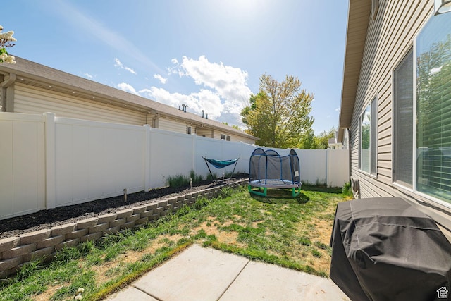 6709 S Empress Ln W, West Jordan, UT 84081 - view of yard with a fenced backyard, a trampoline, and a patio area