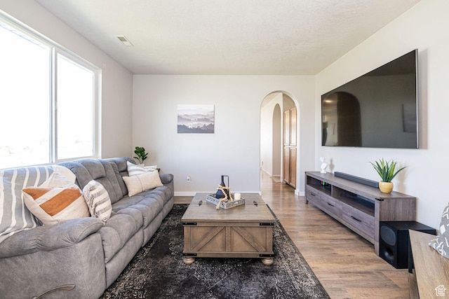 6709 S Empress Ln W, West Jordan, UT 84081 - living room featuring arched walkways, visible vents, a healthy amount of sunlight, and wood finished floors