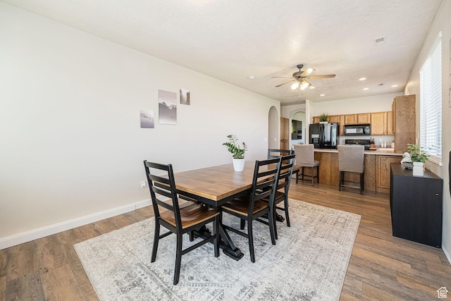 6709 S Empress Ln W, West Jordan, UT 84081 - dining room with baseboards, ceiling fan, recessed lighting, arched walkways, and light wood finished floors