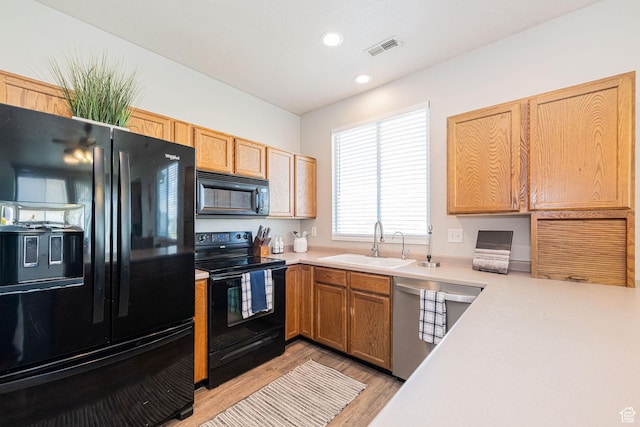 6709 S Empress Ln W, West Jordan, UT 84081 - kitchen with visible vents, light wood-type flooring, light countertops, a sink, and black appliances