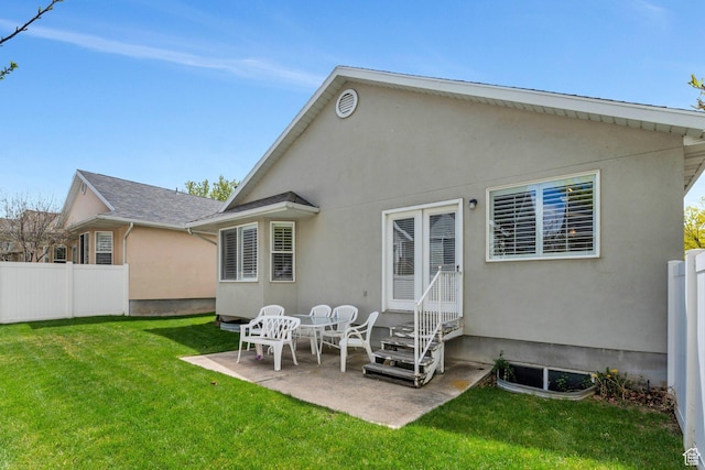 597 E Villager Ln, Midvale, UT 84047 - rear view of property featuring a yard, fence, a patio area, and stucco siding