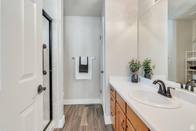 597 E Villager Ln, Midvale, UT 84047 - bathroom with vanity, visible vents, wood finished floors, baseboards, and an enclosed shower