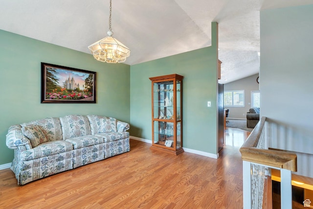 597 E Villager Ln, Midvale, UT 84047 - living room with wood finished floors, baseboards, a textured ceiling, a notable chandelier, and vaulted ceiling