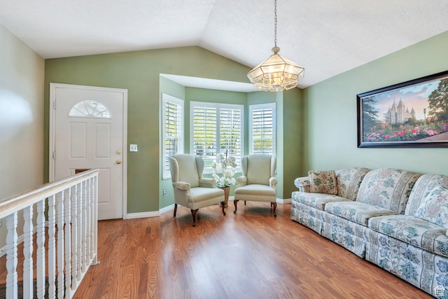 597 E Villager Ln, Midvale, UT 84047 - living area with baseboards, lofted ceiling, wood finished floors, and a notable chandelier