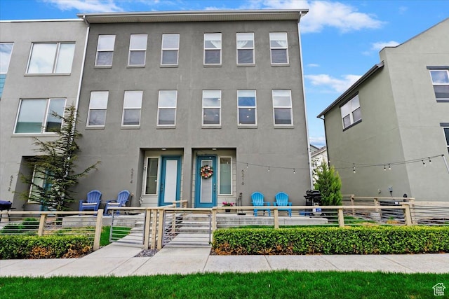 multi unit property with a fenced front yard and stucco siding