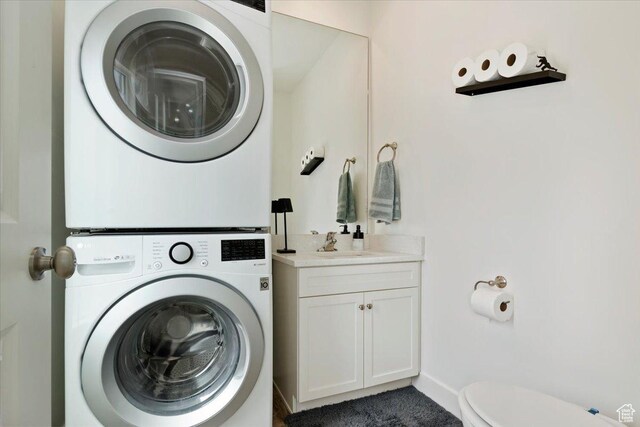 6216 W Birch Run Rd S, South Jordan, UT 84009 - washroom with baseboards, stacked washer / drying machine, a sink, and laundry area