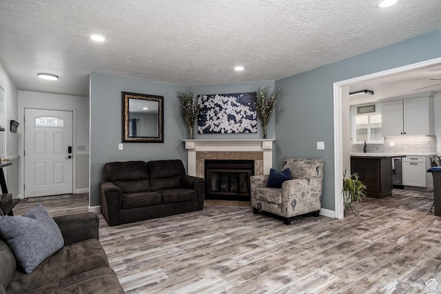 9745 S Tayside Dr W, South Jordan, UT 84009 - living area with wood finished floors, a premium fireplace, a textured ceiling, recessed lighting, and baseboards