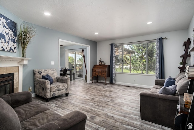 9745 S Tayside Dr W, South Jordan, UT 84009 - living area with wood finished floors, recessed lighting, a tile fireplace, and baseboards