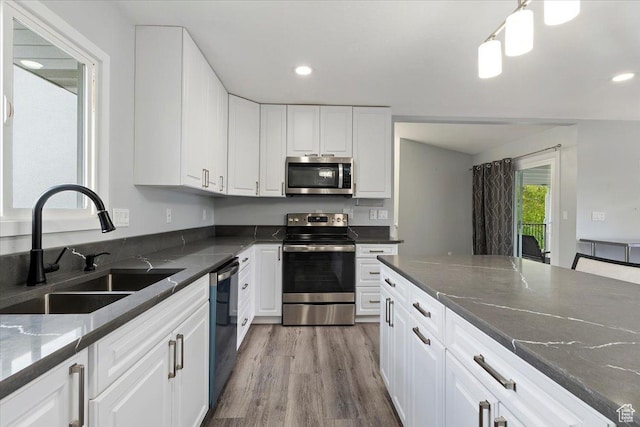4612 S 600 E, Murray, UT 84107 - kitchen with a sink, stainless steel appliances, wood finished floors, and white cabinetry