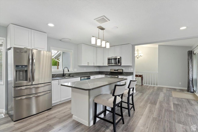 4612 S 600 E, Murray, UT 84107 - kitchen with visible vents, light wood-type flooring, a sink, stainless steel appliances, and white cabinetry