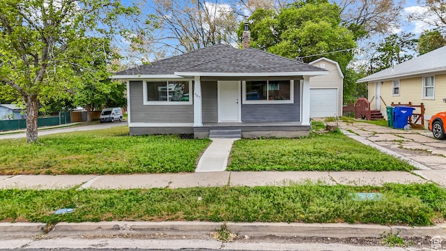 987 S Jefferson Ave E, Ogden, UT 84404 - bungalow featuring covered porch, a chimney, a shingled roof, an outbuilding, and a detached garage