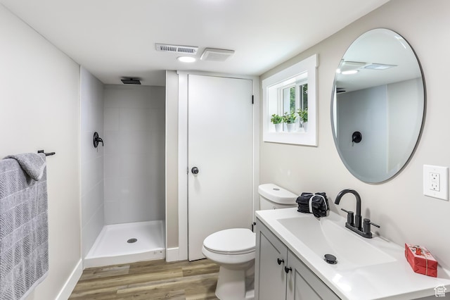 987 S Jefferson Ave E, Ogden, UT 84404 - full bath featuring a tile shower, vanity, toilet, wood finished floors, and visible vents