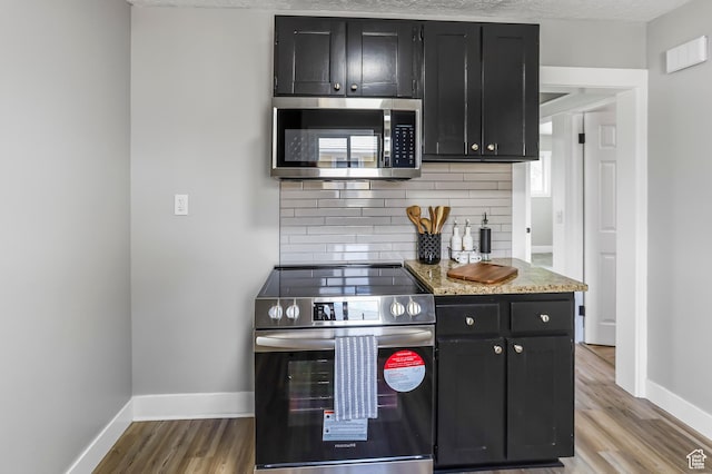 987 S Jefferson Ave E, Ogden, UT 84404 - kitchen with dark cabinets, appliances with stainless steel finishes, decorative backsplash, and baseboards