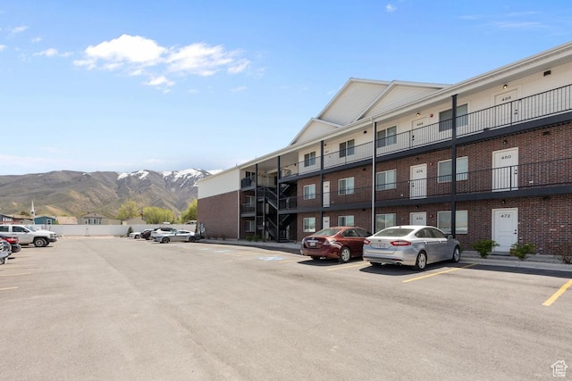 view of building exterior with a mountain view and uncovered parking