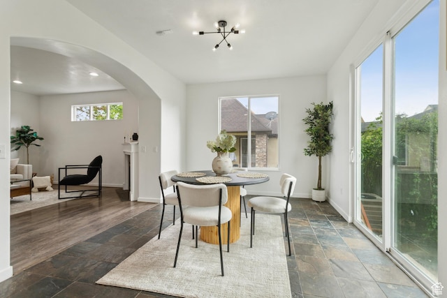 11572 S Harvest Rain Ave, South Jordan, UT 84009 - dining area with stone tile flooring, arched walkways, healthy amount of natural light, baseboards, and recessed lighting