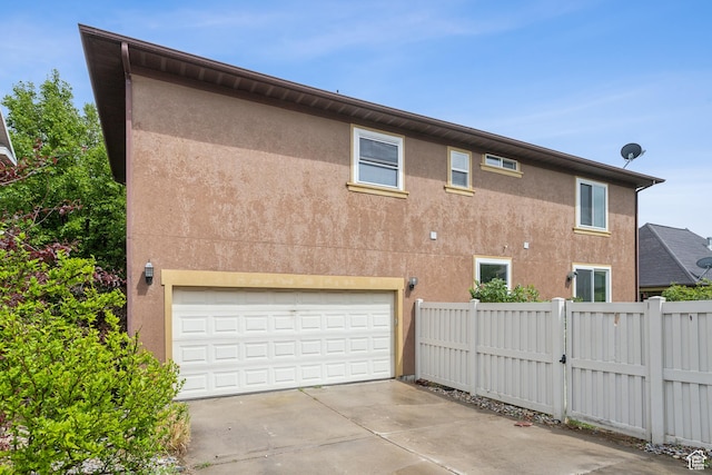 11572 S Harvest Rain Ave, South Jordan, UT 84009 - view of property exterior featuring fence, concrete driveway, an attached garage, and stucco siding