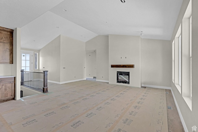 2881 N 3475 W Unit 17, Plain City, UT 84404 - unfurnished living room with baseboards, a fireplace, and vaulted ceiling