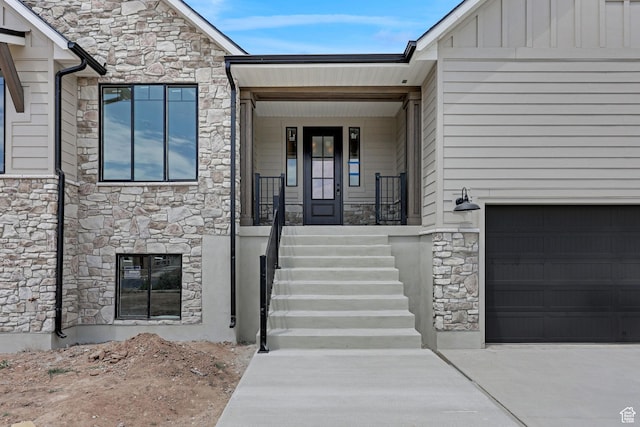 2881 N 3475 W Unit 17, Plain City, UT 84404 - entrance to property with stone siding, concrete driveway, covered porch, an attached garage, and board and batten siding