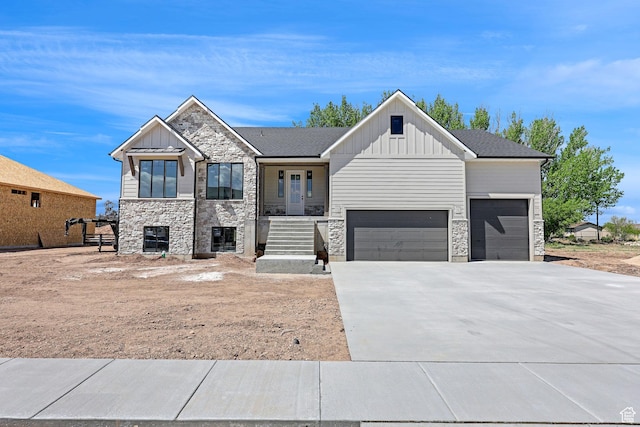 view of front facade featuring a garage, board and batten siding, stone siding, and concrete driveway