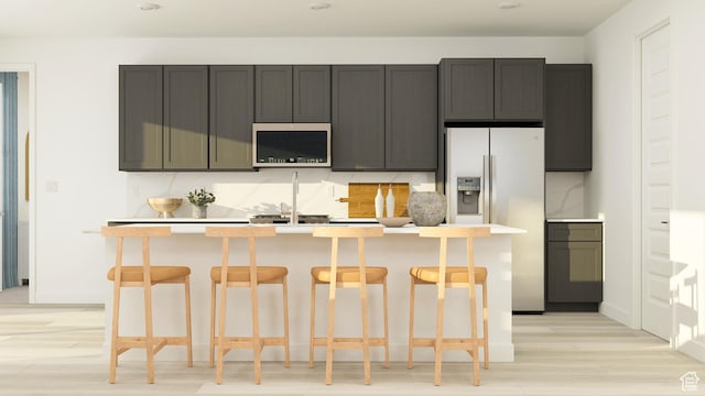 546 S Cecita Way, St George, UT 84770 - kitchen with a kitchen island with sink, a kitchen breakfast bar, light wood-type flooring, light countertops, and stainless steel appliances