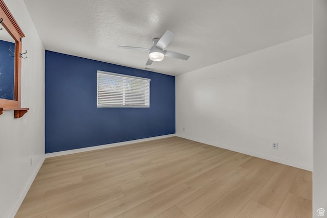 unfurnished room with baseboards, ceiling fan, and wood finished floors