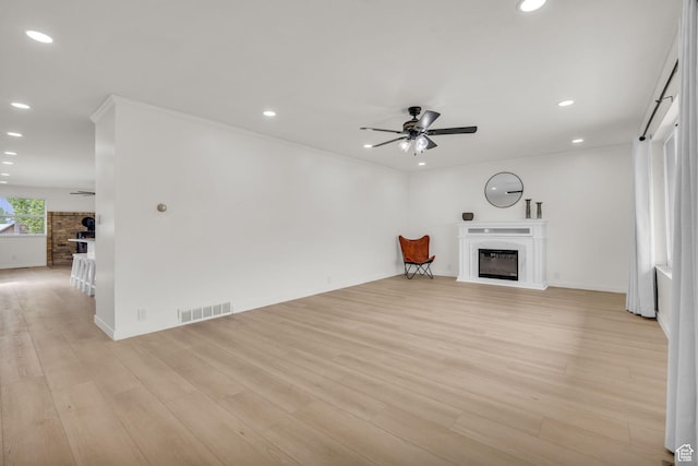 unfurnished living room featuring visible vents, recessed lighting, and a glass covered fireplace