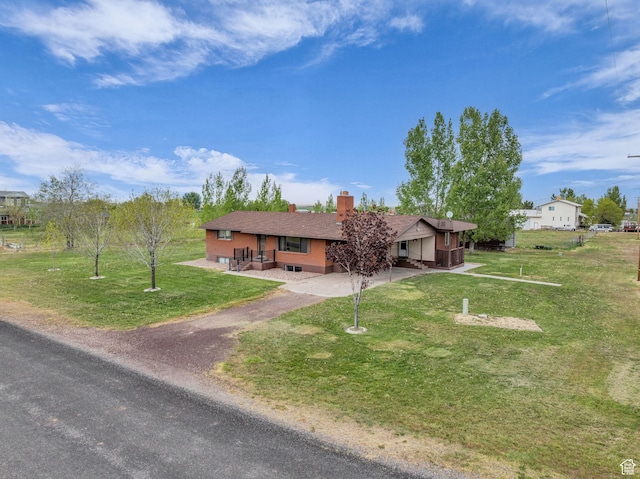 ranch-style house featuring dirt driveway, a chimney, and a front lawn