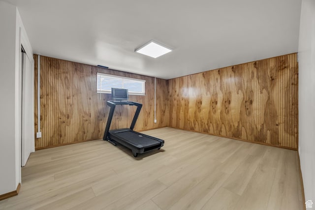 workout room with wooden walls and light wood finished floors