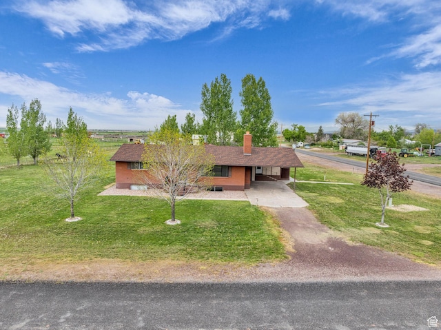 ranch-style house with an attached carport, driveway, and a front yard