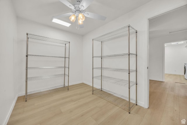 walk in closet featuring washer / clothes dryer, a ceiling fan, and wood finished floors