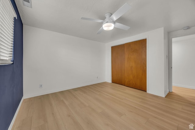 unfurnished bedroom with light wood-style floors, baseboards, a closet, and visible vents