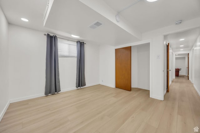 unfurnished bedroom featuring baseboards, light wood-style flooring, and visible vents