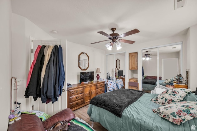 2990 E Riverside Dr Unit 118, St George, UT 84790 - bedroom with visible vents, a ceiling fan, two closets, and light wood-type flooring