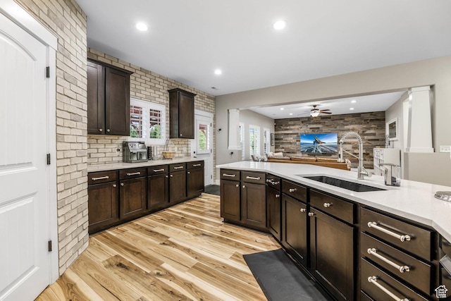 5764 Greenwich Cir, Stansbury Park, UT 84074 - kitchen with dark brown cabinetry, a ceiling fan, a sink, light countertops, and light wood-style flooring