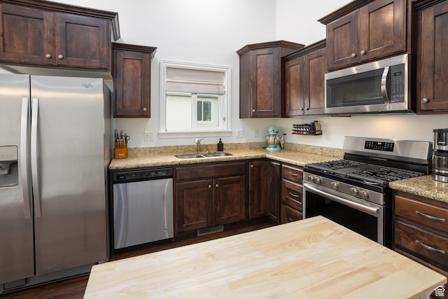 940 N 90 W, Santaquin, UT 84655 - kitchen with appliances with stainless steel finishes, dark brown cabinetry, dark wood-style flooring, and butcher block countertops