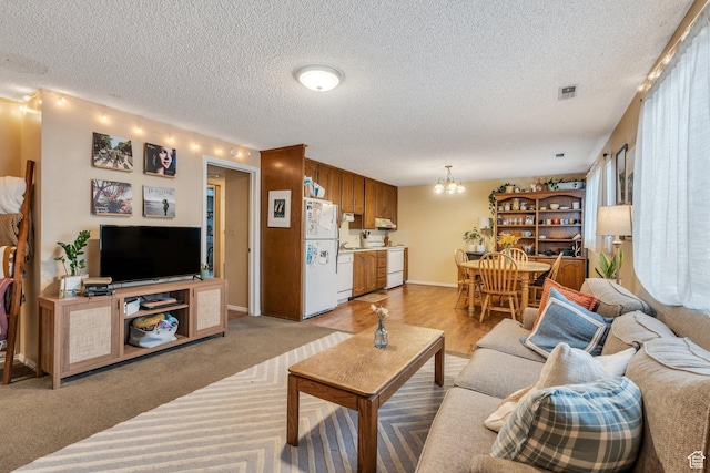 161 E 700 N Unit 10, Provo, UT 84606 - living room with an inviting chandelier, baseboards, a textured ceiling, and visible vents