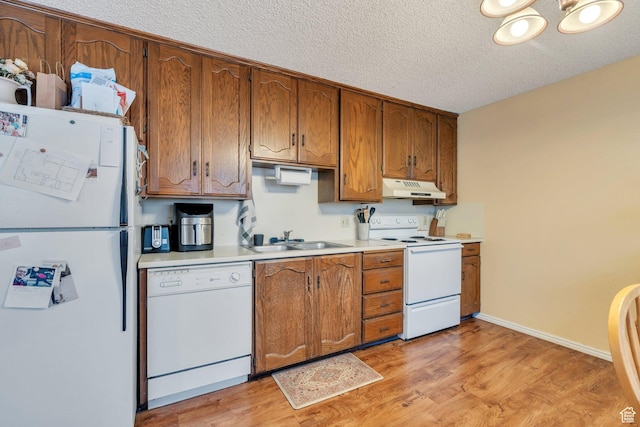 161 E 700 N Unit 10, Provo, UT 84606 - kitchen with brown cabinetry, a textured ceiling, a sink, under cabinet range hood, and white appliances
