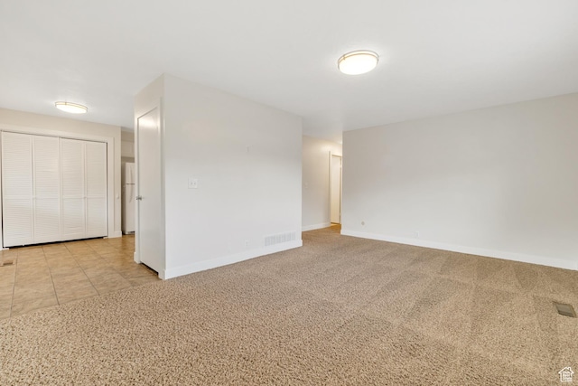 carpeted spare room with baseboards and visible vents