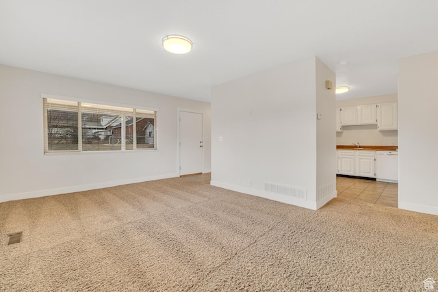 unfurnished room with baseboards, light carpet, and visible vents