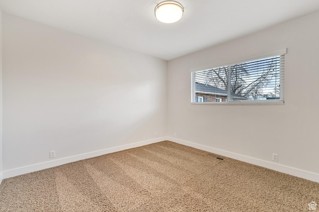 carpeted spare room with baseboards and visible vents