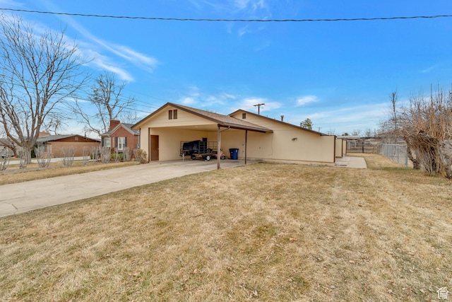view of front of property with concrete driveway, fence, a front yard, and an attached carport