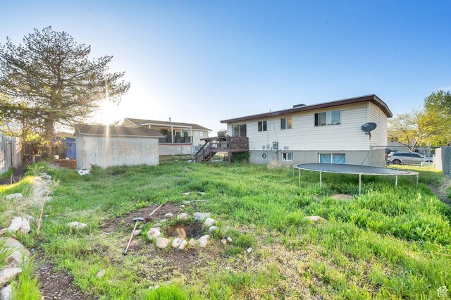 7979 W 3320 S, Magna, UT 84044 - rear view of property featuring a trampoline, fence, a wooden deck, and stairway