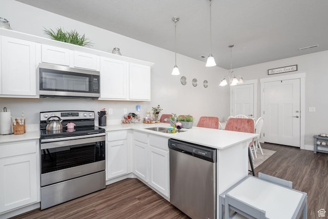1809 W Terra Vista Ln Unit H101, Saratoga Springs, UT 84045 - kitchen with a peninsula, dark wood-type flooring, light countertops, a sink, and appliances with stainless steel finishes