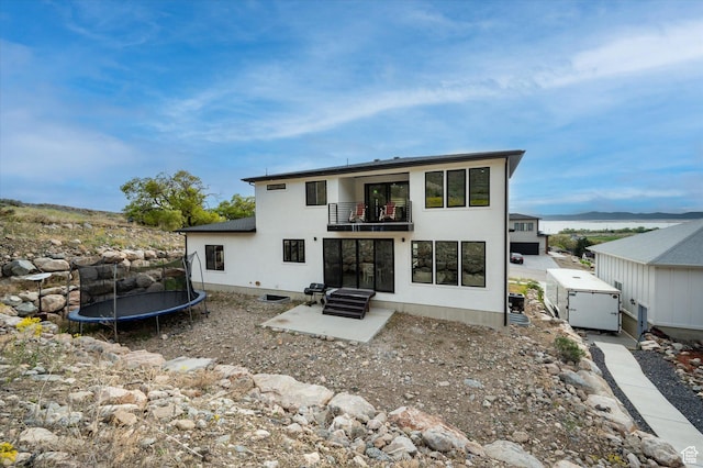 833 S 260 E, Willard, UT 84340 - back of house with a balcony, a trampoline, and stucco siding