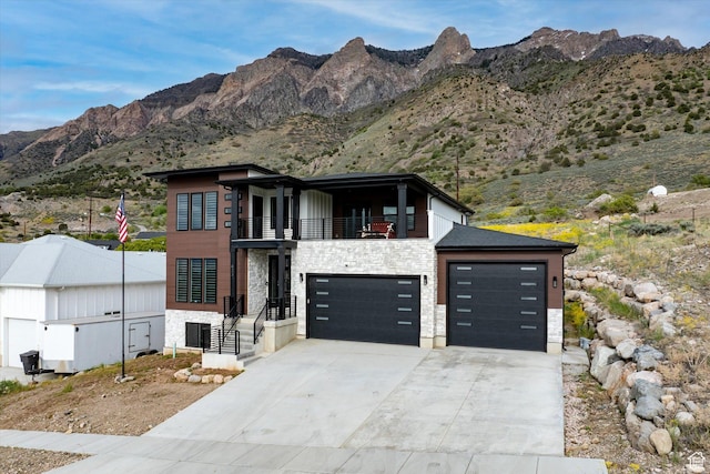 833 S 260 E, Willard, UT 84340 - contemporary home with a mountain view, a balcony, stone siding, and concrete driveway